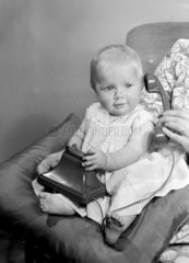 Baby playing with a telephone  1950.