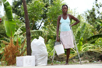 Leogane  Haiti  eine Beinamputierte Frau hilft ehrenamtlich bei der Verteilung von Hilfsguetern