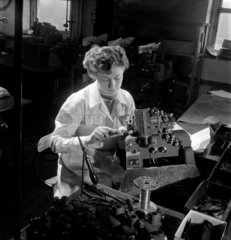A female worker finishes a 16mm sound projector Mitchelldean  1953.