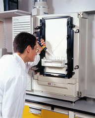 Molecular geneticist loading samples onto an automated DNA sequencer.