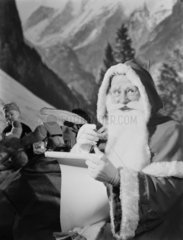 Father Christmas checking his list  1950.