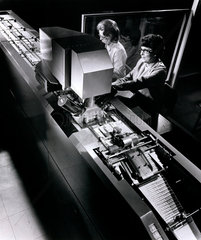 Littlewoods Pools: female workers feed coupons into computer sorting machine.