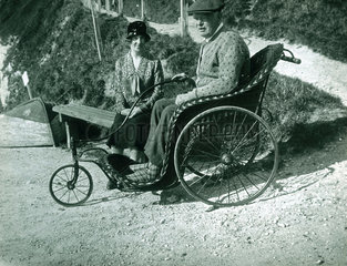Man in an invalid carriage  c 1920.