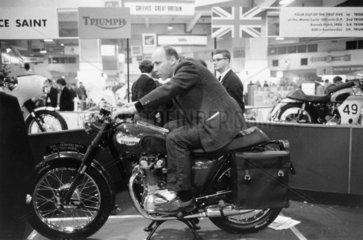 Man on a Triumph motorcycle at a motorcycle show  UK  1967.