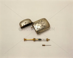 Hypodermic syringe with a spare needle and metal case  late 19th century.