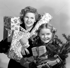 Woman and child carrying Christmas presents  1948.