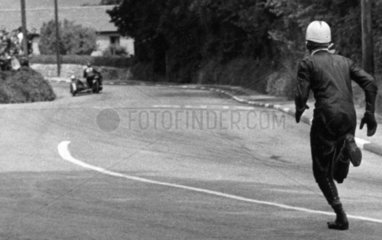 Sidecar passenger running on the track  TT race  Isle of Man  June 1960.