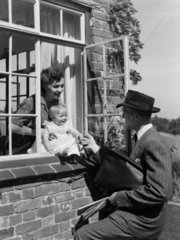 Man saying goodbye to a woman and baby  1951.
