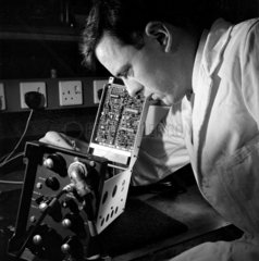 An electronic engineer checks a section of a data transmission item  MEL  1964.