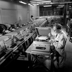A line of completed Envoy telex machines are checked  1968.