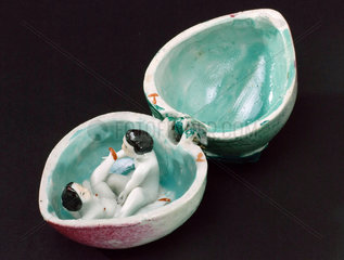 Porcelain fruit containing a man and woman having sex.
