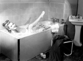 Woman having a bubble bath  1950.