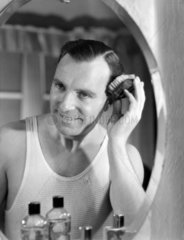Man brushing his hair  c 1945.