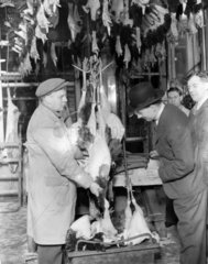Butcher selling turkeys during the Christmas period  19 December 1932.