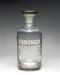 Clear glass reagent bottle labelled ‘AMMONIUM MOLYBDATE’  1930.