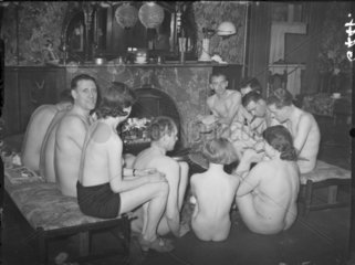 Nudists gathered at the fireside  1938.