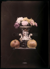 Autochrome of flowers in a vase with fruit  c 1908.