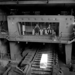 Steel plant control cabin with fresh hot ingot passing underneath  1957.