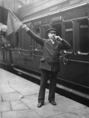 Passenger guard with a flag and whistle  c 1907.