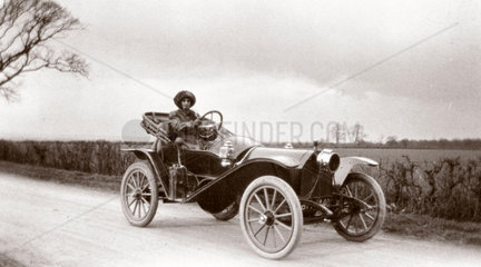Woman driving a motor car  c 1912.