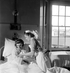 Trainee nurse with mother and child  Royal Free Hospital  1952.