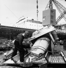 An acetylene burner cutts through part of the SS Britannic  breakers yard  1961.