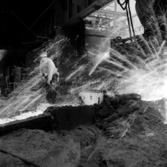 A steelworker taps a blast furnace at Consett Iron Company  1956.