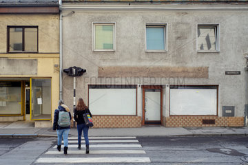 Linz  Oesterreich  Maedchen ueberqueren an einem Zebrastreifen eine Strasse