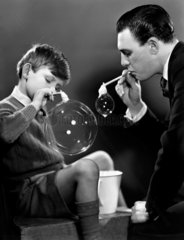 Father and son blowing bubbles  c 1948.
