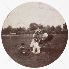 Three children with a baby in a pram  c 1890.