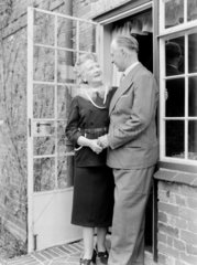 Elderly couple in the doorway of their home  1950.