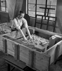 A worker prepares large sand mould for foundry   Lloyds  Burton  1957.