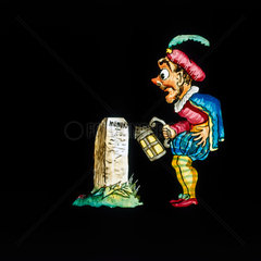 A man by a tombstone. Hand-coloured magic l
