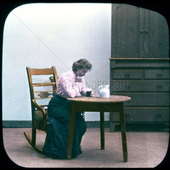 Woman with drink in rocking chair  c 1895.
