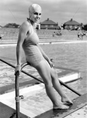 Woman wearing a bathing costume posing by a swimming pool  c 1920s.