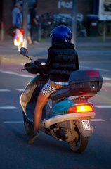 Muenster  Deutschland  Frau faehrt in der Nacht mit ihrem Motorroller