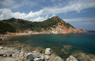 Arbatax  Italien  Touristen an einer Meeresbuchtauf die felsige Kueste mit den roten Felsen aus Porphyran