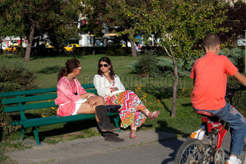 Bukarest  Rumaenien  modische Frauen sitzen und plaudern auf einer Parkbank im Unirii Park