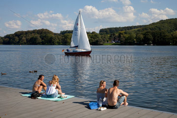 Essen  Deutschland  Segelboot auf dem Baldeneysee und Menschen am Bootssteg