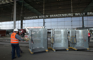 Schoenefeld  Deutschland  Flughafenmitarbeiter mit Transportwagen vor dem Terminalgebaeude des Flughafen Berlin Brandenburg