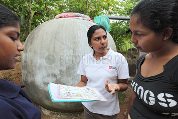 Ambalangoda  Sri Lanka  Malteser-Mitarbeiter erklaeren das Verfahren einer Regenwasserauffanganlage