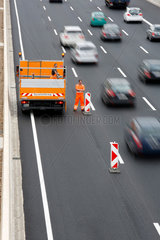 Koeln  Deutschland  Koelner Autobahnring  ein Mitarbeiter vom Strassenbau baut eine Autobahnbaustelle ab