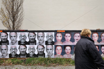 Berlin  Deutschland  Plakate mit unterschiedlichen Gesichtern an einem Bauzaun