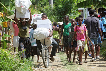 Leogane  Haiti  Einheimische mit Hilfsguetern auf der Strasse