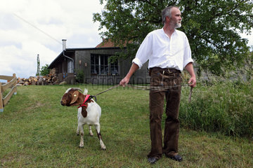 Neu Kaetwin  Deutschland  Mann geht mit seinem Ziegenbock spazieren