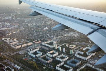 Berlin  Deutschland  Tragflaeche eines Passagierflugzeugs und Plattenbauten in Berlin-Neu-Hohenschoenhausen