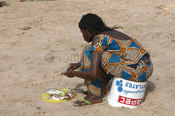 Bakau  Gambia  Einheimische nimmt Fische am Strand aus