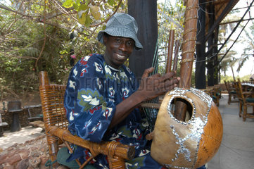 Abuko  Gambia  Mann spielt einheimische Folklore im Abuko-Naturschutzgebiet