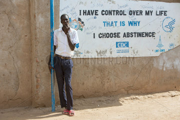 Kakuma  Kenia - Schueler lehnt im Fluechtlingslager Kakuma an einer Wand mit Aufschrift- I HAVE CONTROL OVER MY LIFE. THAT IS WHY I CHOOSE ABSTINENTE.