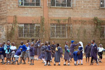 Nairobi  Kenia - Schueler und Schuelerinnen in Schuluniformen spielen auf dem Schulhof des St. John’s Community Centers Pumwani.